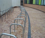 double row of galvanised Sheffield cycle stands installed in a curved layout